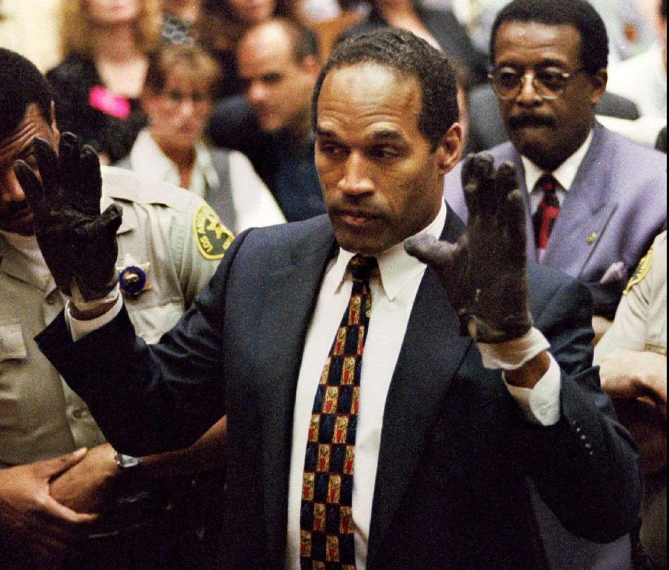 O.J. Simpson, wearing the blood stained gloves found by Los Angeles Police and entered into evidence in Simpson's murder trial, displays his hands to the jury at the request of prosecutor Christopher Darden in this file photograph from June 15, 1995 (REUTERS)