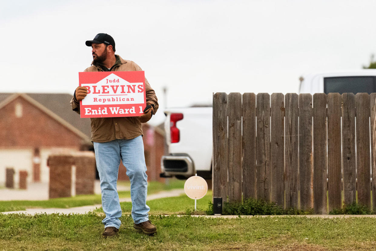 Judd Blevins holds a campaign sign in Enid. (Michael Noble Jr. for NBC News)