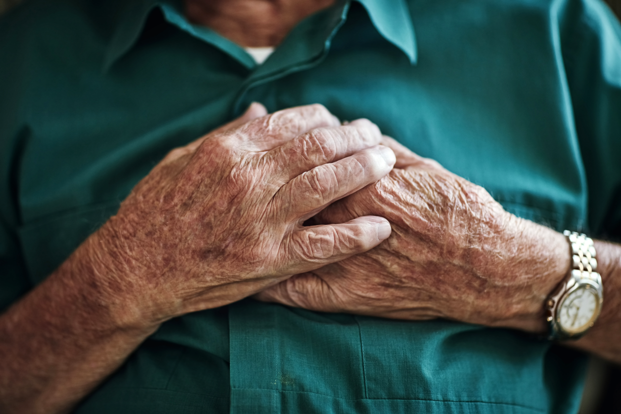 Man holding his chest due to heart disease