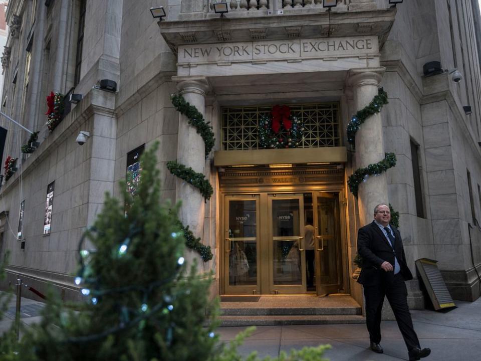  People walk in and out of the New York Stock Exchange (NYSE) on Wall Street.