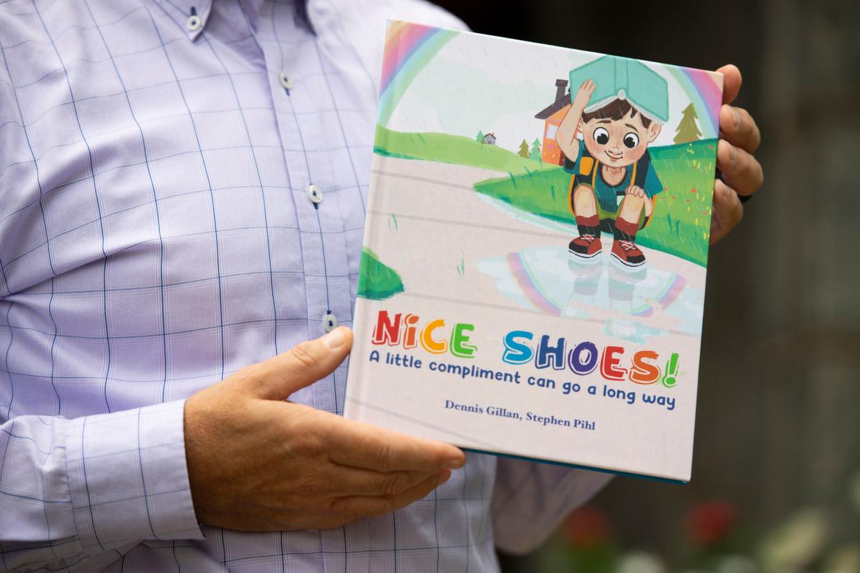 Dennis Gillan poses for a portrait in front of his office building with the book "Nice Shoes!" that he coauthored with Stephen Pihl in Greenville on Thursday, August 18.