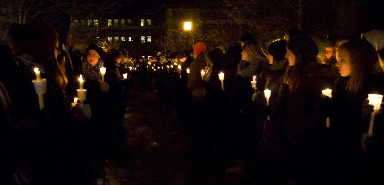 A path is lit for members of the Purdue All-American Marching Band during a vigil for a teaching assistant who was fatally shot on campus at Purdue University, on Tuesday, Jan. 21, 2014, in West Lafayette, Ind. The victim was identified as Andrew Boldt, 21, a senior in electrical engineering from Wisconsin who lived on campus, according to Purdue. Another student, Cody Cousins, was arrested on a preliminary charge of murder, athourities said. (AP Photo/The Journal & Courier, Michael Heinz) MANDATORY CREDIT; NO SALES