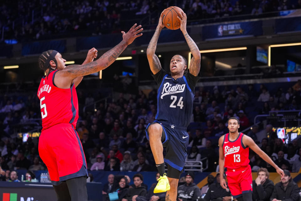 Jordan Hawkins (24) of the New Orleans Pelicans shoots over Paolo Banchero of the Orlando Magic during an NBA Rising Stars basketball game in Indianapolis, Friday, Feb. 16, 2024. (AP Photo/Michael Conroy)