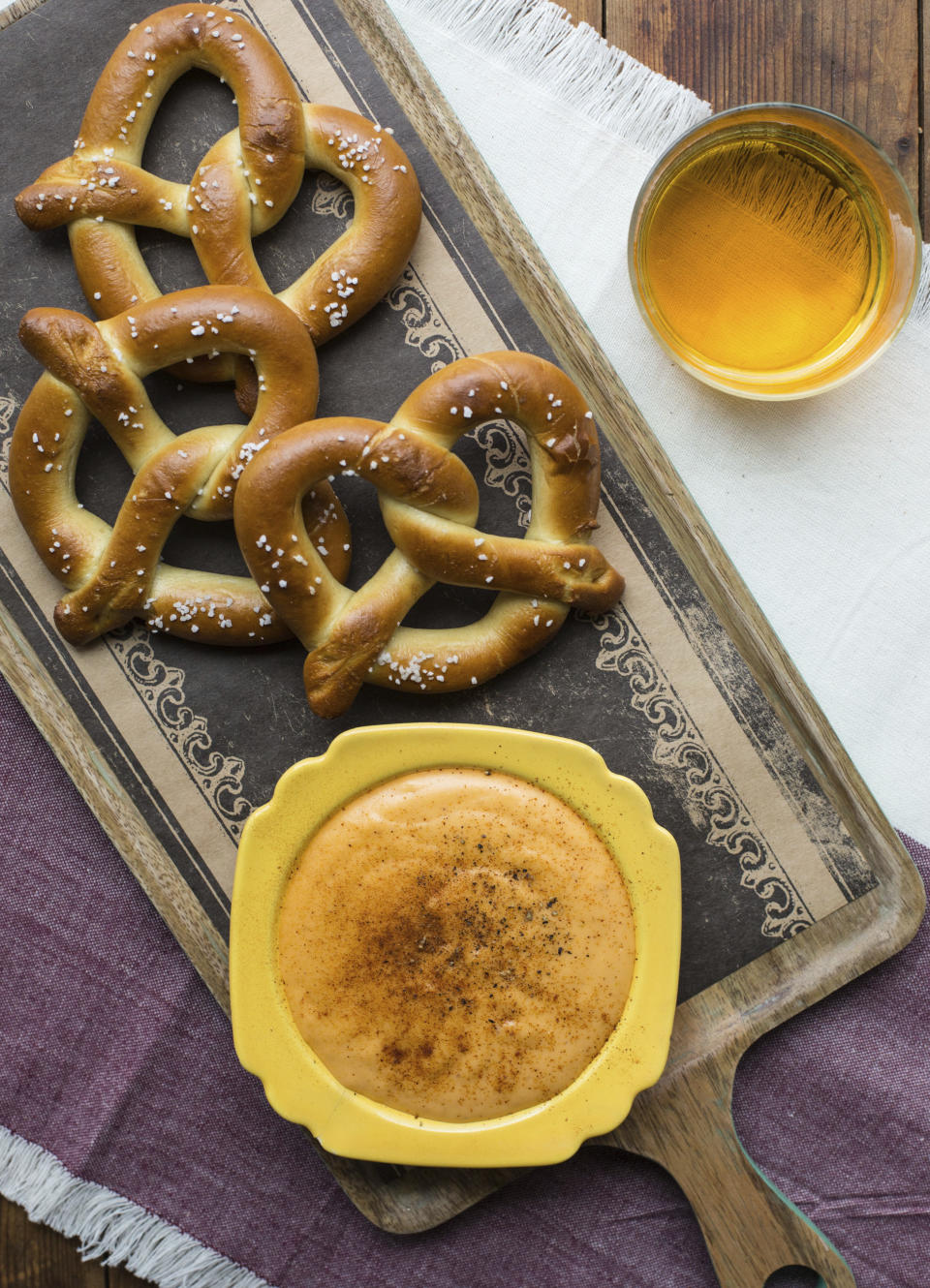 This November 2016 photo shows soft pretzels with hot Cheddar cheese beer dip in New York. This dish is from a recipe by Katie Workman. (Sarah Crowder via AP)