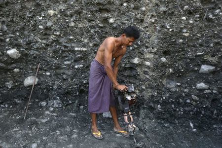 Miners search for jade stones at a mine dump at a Hpakant jade mine in Kachin state, Myanmar November 27, 2015. REUTERS/Soe Zeya Tun