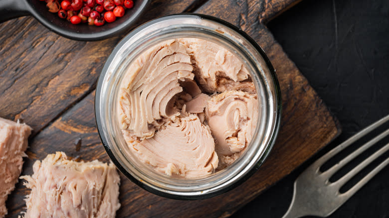 Open tuna can on wooden table