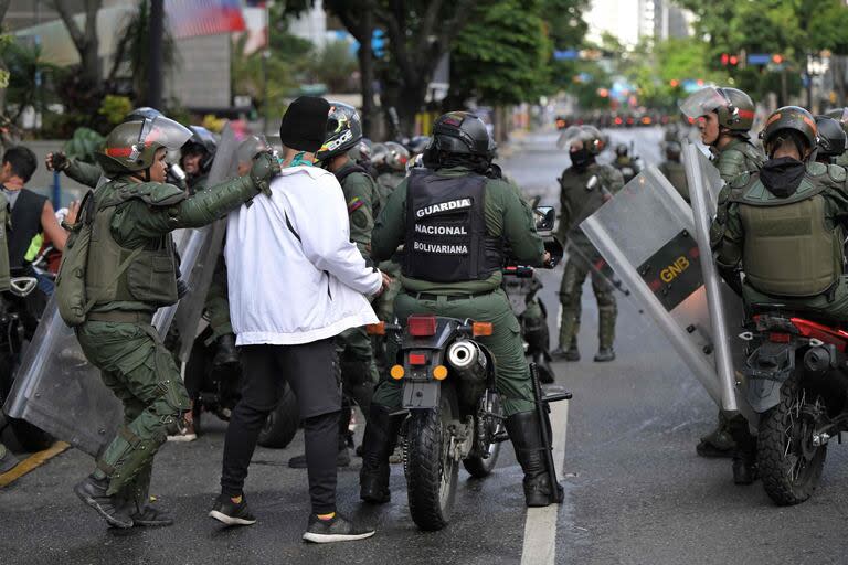 Miembros del escuadrón antidisturbios de la Guardia Nacional Bolivariana (GNB) detienen a opositores al presidente venezolano Nicolás Maduro que participaban en una manifestación, en el barrio de Chacao, en Caracas, el 30 de julio de 2024.