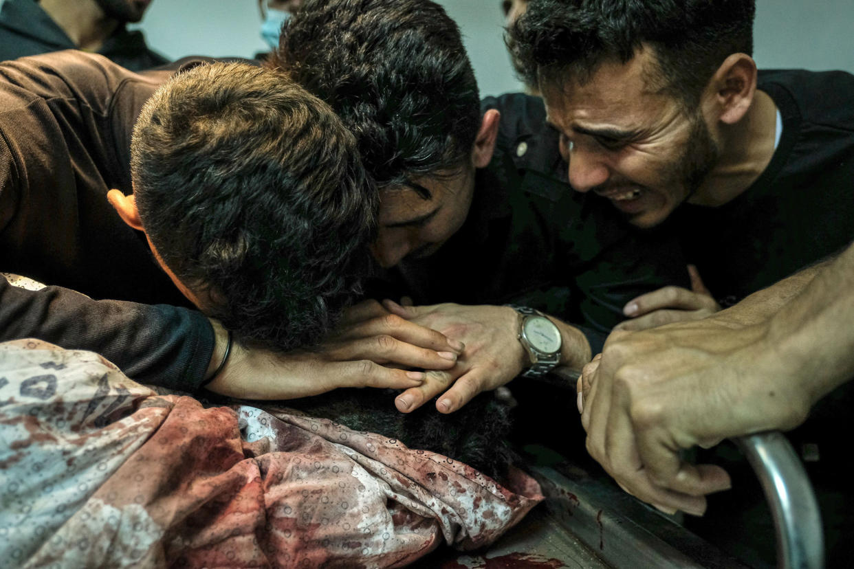 Image: Relatives of Palestinian Izz al-Deen Helles during his bid farewell at Al-Shifa Hospital (Fatima Shbair / Getty Images)