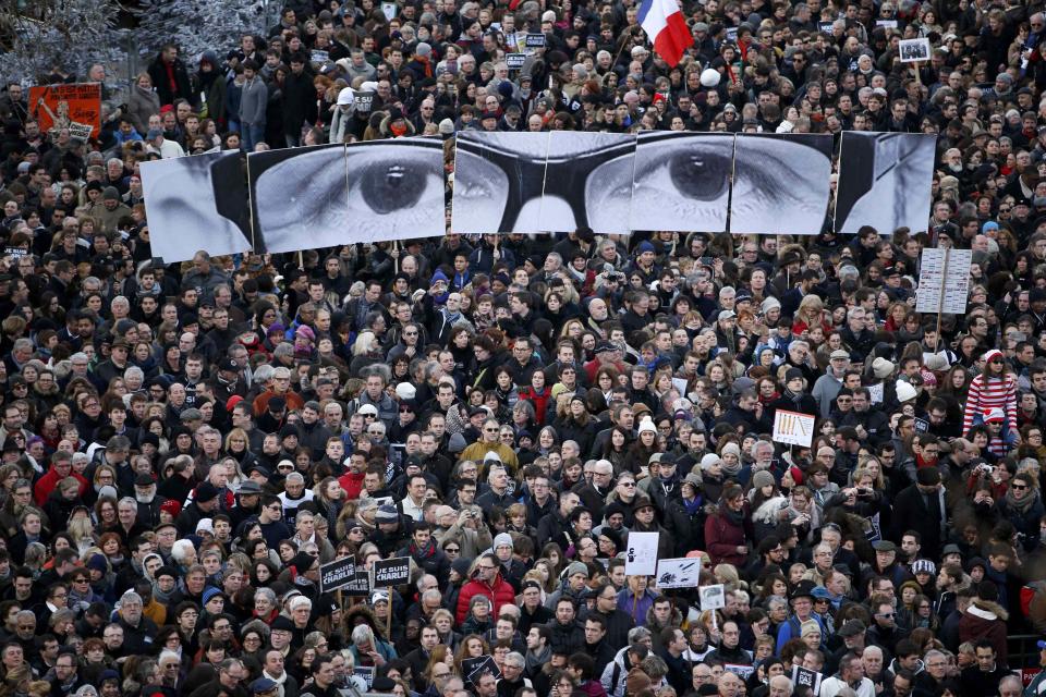REFILE - ADDITIONAL CAPTION INFORMATION People hold panels to create the eyes of late Charlie Hebdo editor Stephane Charbonnier, known as "Charb", as hundreds of thousands of French citizens take part in a solidarity march (Marche Republicaine) in the streets of Paris January 11, 2015. French citizens, joined by dozens of foreign leaders, among them Arab and Muslim representatives, took part in a march on Sunday in an unprecedented tribute to this week's victims following the shootings by gunmen at the offices of the satirical weekly newspaper Charlie Hebdo, the killing of a policewoman in Montrouge, and the hostage-taking at a kosher supermarket at the Porte de Vincennes. REUTERS/Yves Herman (FRANCE - Tags: CRIME LAW POLITICS CIVIL UNREST TPX IMAGES OF THE DAY SOCIETY)