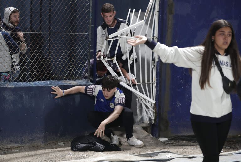 Hinchas de Gimnasia y Esgrima intentan escapar de los gases lacrimógenos, durante los graves incidentes