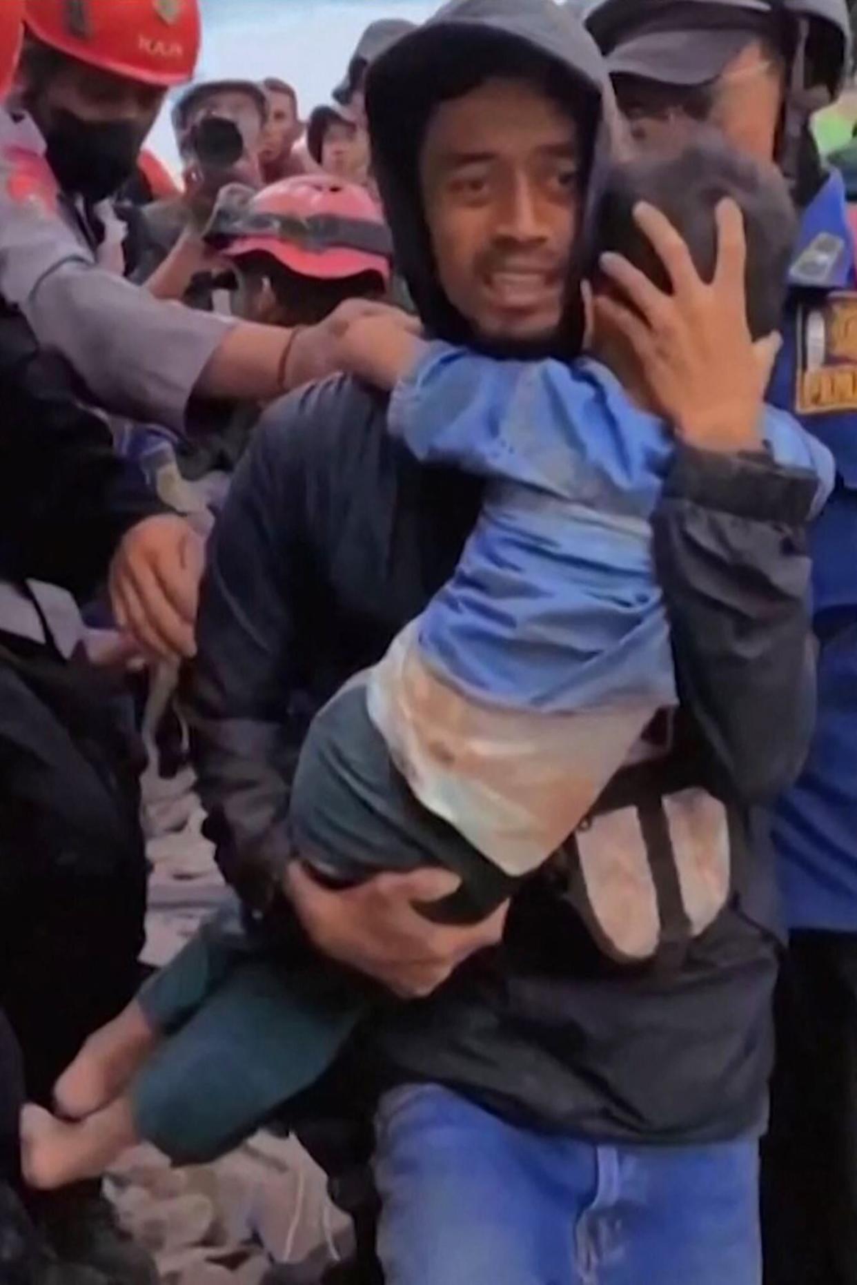 This frame grab taken from mobile phone video footage released by Bogor Administration shows a six-year-old boy being pulled out of the rubble in Cianjur, West Java on November 23, 2022, following a 5.6-magnitude earthquake