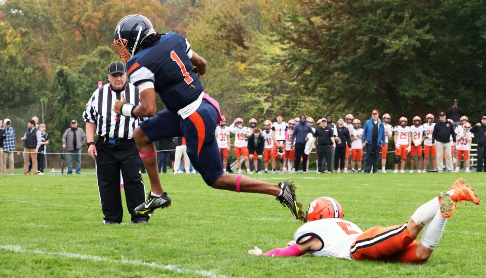 Milton Academy quarterback Qur'an McNeill scores a touchdown past Thayer defender Tyler Brewington during a game on Saturday, Oct. 7, 2023.
