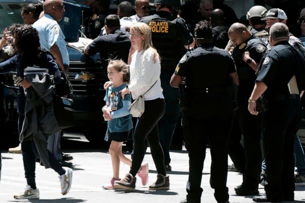 PHOTO: People stand outside a commercial building after a shooting, May 3, 2023, in Atlanta. (Ben Gray/AP)