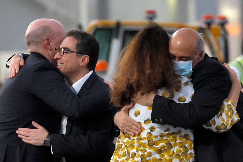 US citizens Siamak Namazi (2nd-L) and Morad Tahbaz (R) are welcomed by people upon disembarking from a Qatari jet upon their arrival at the Doha International Airport in Doha on Sept. 18, 2023. Five US detainees, three previously identified as Siamak Namazi, Morad Tahbaz and Emad Sharqi and two who wish to remain anonymous, released by Iran landed in Doha in a prisoner swap on September 18 after $6 billion in frozen funds were transferred to Iranian accounts in Qatar.