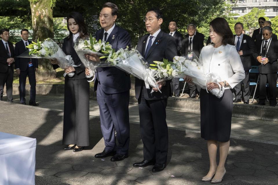 South Korea's President Yoon Suk Yeol, center left, his wife Kim Keon Hee, left, Japan's Prime Minister Fumio Kishida and his wife Yuko Kishida (R) lay flowers at the Monument in Memory of the Korean Victims of the A-bomb near the Peace Park Memorial in Hiroshima, western Japan Sunday, May 21, 2023, on the sidelines of the G7 Summit Leaders' Meeting. (Yuichi Yamazaki/Pool Photo via AP)