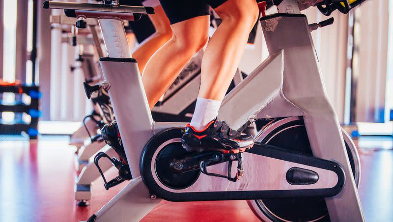 People ride stationary exercise bikes. Serotonin deficiency can negatively impact mental and physical health. 