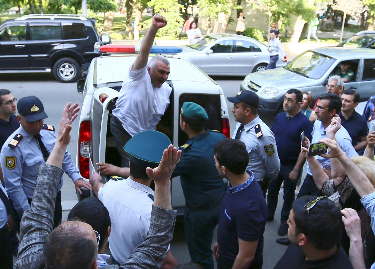 Azerbaijani Journalist Afgan Mukhtarli greets supporters as he is taken to the court in Baku, Azerbaijan, May 31, 2017. REUTERS/Aziz Karimov