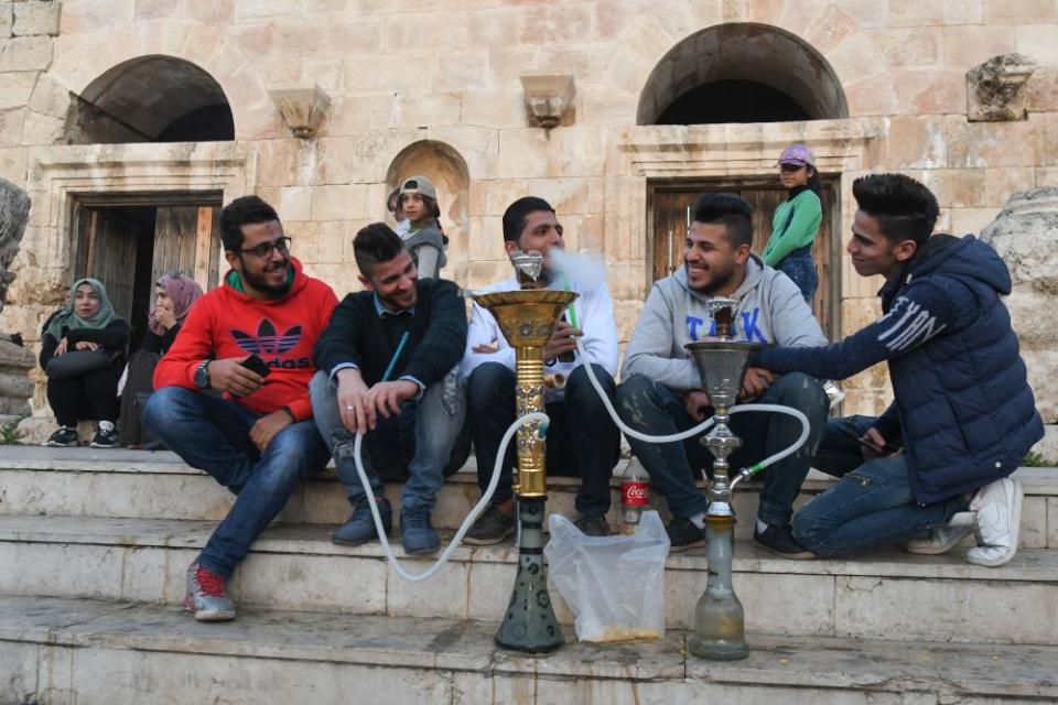 Young men smoke water-pipes in the Old Town of Amman.