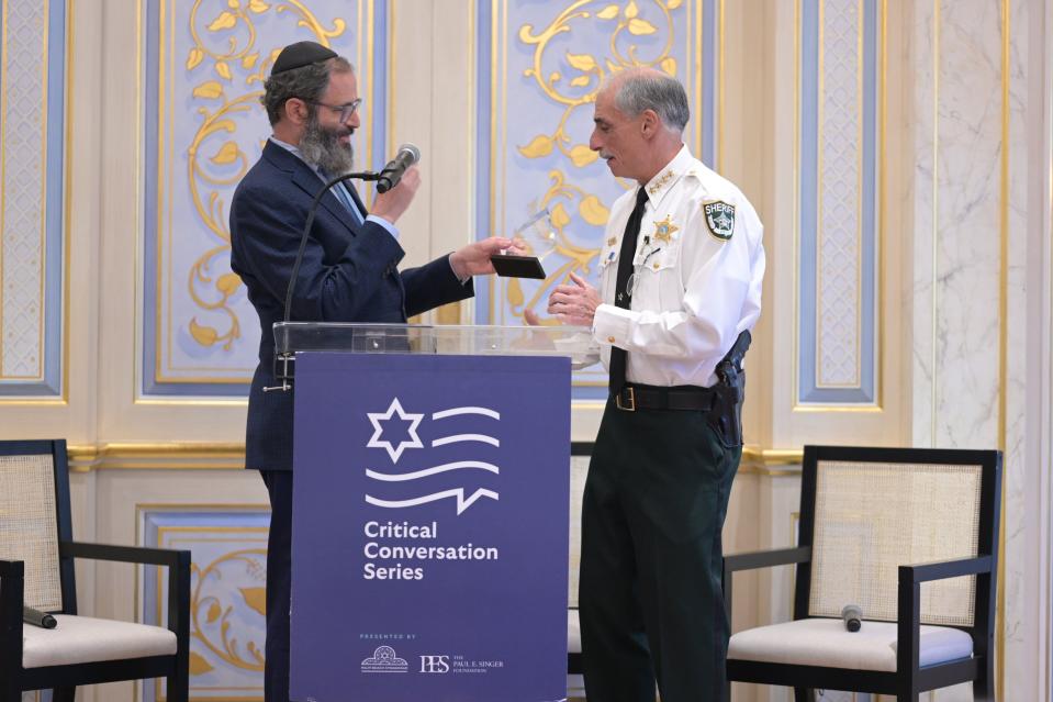 Volusia County Sheriff Mike Chitwood receives a Critical Citizen Award from Rabbi Moshe Scheiner at the Palm Beach Synagogue Thursday.