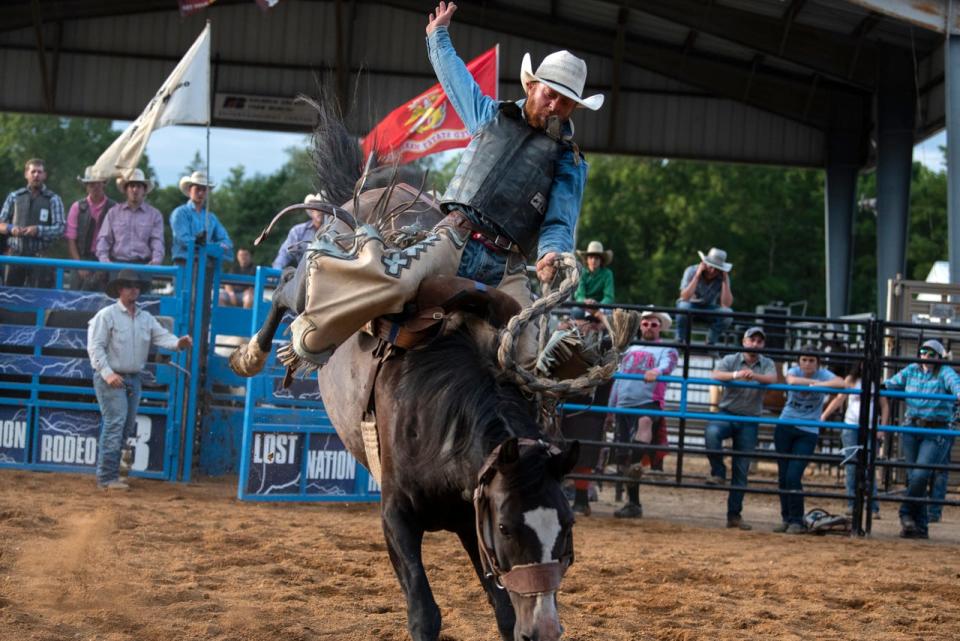Cowboy John Miller rides in the saddle bronc competition of the Lost Nations Rodeo on Wednesday, Aug. 14, 2019 at the Calhoun County fairgrounds in Marshall, Mich.