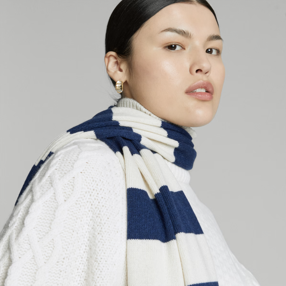 asian model wearing navy and white striped The Cashmere Scarf in bright navy/bone (Photo via Everlane)