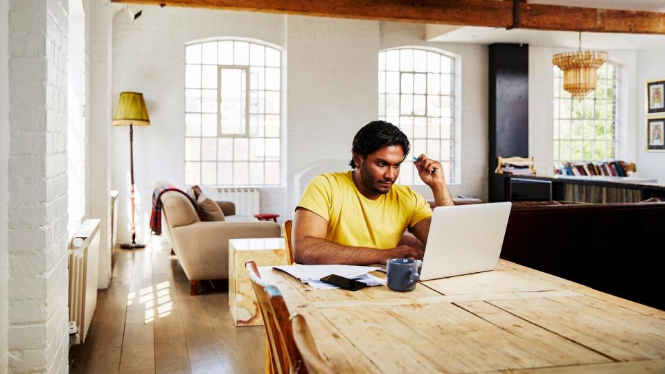 Man sitting at home and working on laptop computer