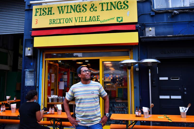 Brian Danclair, owner of Fish, Wings & Tings, stands outside his restaurant at Brixton Village in London