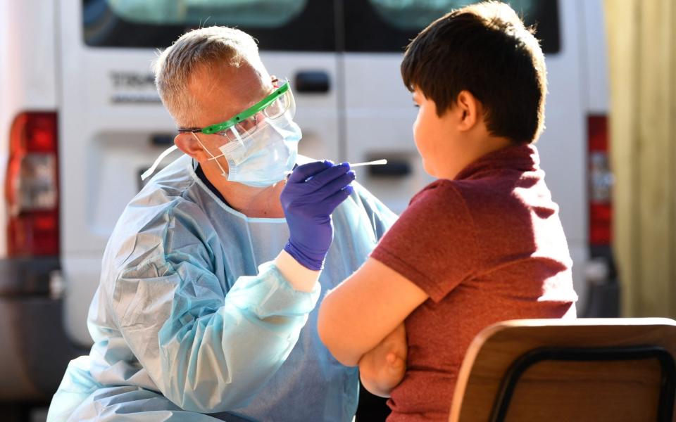 A nurse swabs a child in Melbourne - EPA