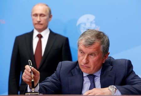 FILE PHOTO: Russia's President Putin and Rosneft CEO Igor Sechin attend a signing ceremony at the St. Petersburg International Economic Forum 2014 in St. Petersburg