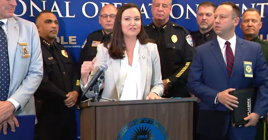 A woman in a suit speaking at a lectern