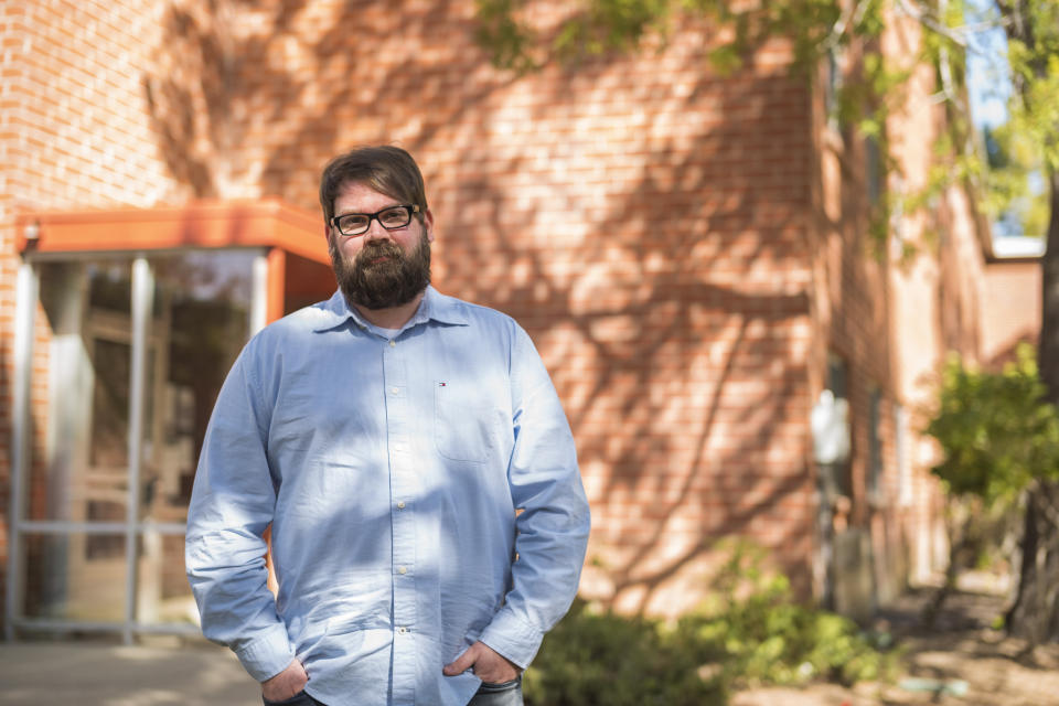 Chris Lambert, a musician and recording engineer, poses Thursday, April 15, 2021, in front of Muir Hall dormitory at California Polytechnic University in San Luis Obispo, Calif. Lambert started a podcast to document the 1996 disappearance of Kristin Smart, who was a college student at Cal Poly and lived in Muir Hall when she disappeared. On Tuesday, April 13, 2021, the San Luis Obispo County sheriff announced arrests in the 25-year-old case, crediting Lambert with helping bring in witnesses that propelled the case forward. (AP Photo/Nic Coury)