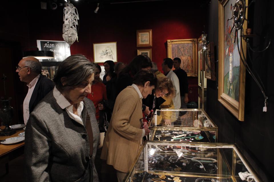 This Oct. 23, 2012 photo shows visitors inspecting jewels and paintings at the Drouot auction's house, in Paris. The famous auction house in Paris offers 16 functioning auctions rooms and is the world's largest auction house open to the public. (AP Photo/Christophe Ena)