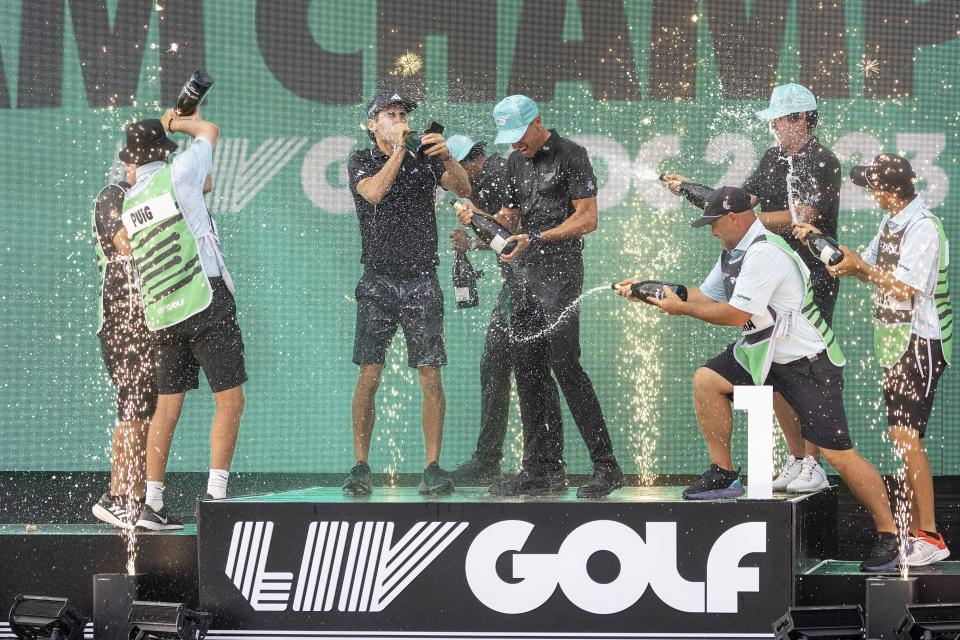 Team champions David Puig, Sebastián Muñoz, Mito Pereira, Captain Joaquín Niemann of Torque GC and their caddies celebrate on stage with the team trophy during LIV Golf DC at the Trump National Golf Club in Washington Sunday, May 28, 2023, in Sterling, Virginia. (Photo by Chris Trotman/LIV Golf via AP, File)