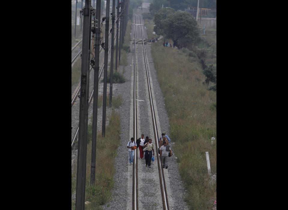 In this May 12, 2012 photo, Central American migrants walk on a railway in Lecheria, on the outskirts of Mexico City. While the number of Mexicans heading to the U.S. has dropped dramatically, a surge of Central American migrants is making the 1,000-mile northbound journey this year, fueled in large part by the rising violence brought by the spread of Mexican drug cartels. (AP Photo/Marco Ugarte)