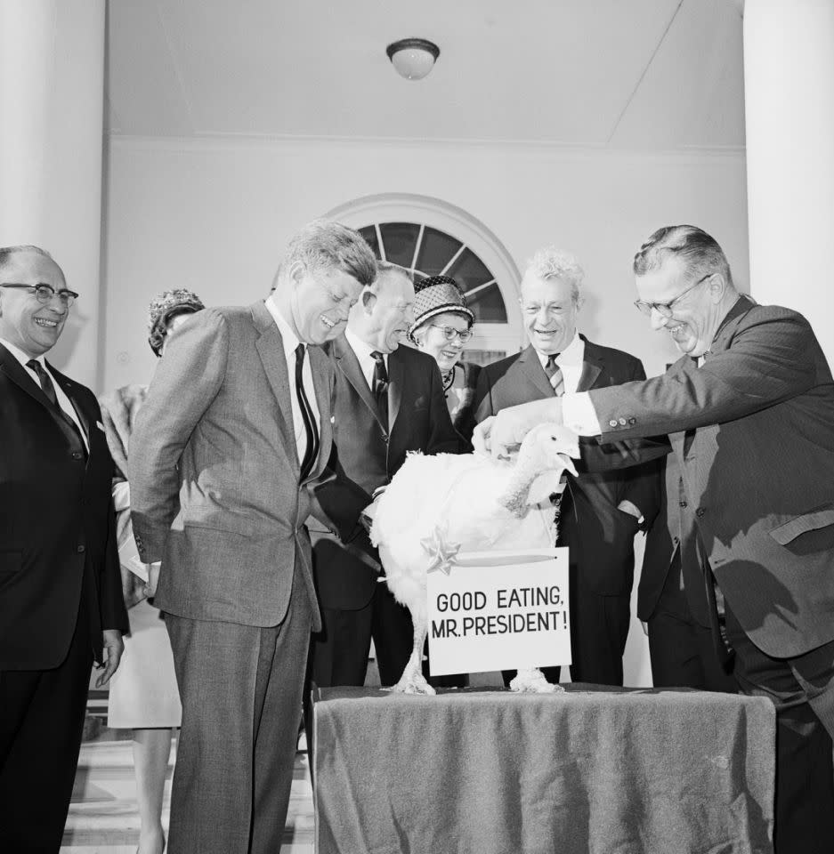 <p>President Kennedy admires a 55-pound turkey, which wears a sign reading “Good Eating, Mr. President!” The turkey was intended for the Kennedy’s Thanksgiving dinner; however, the President granted it freedom on Nov. 19, 1963. (Photo: Bettmann/Corbis/Getty Images) </p>