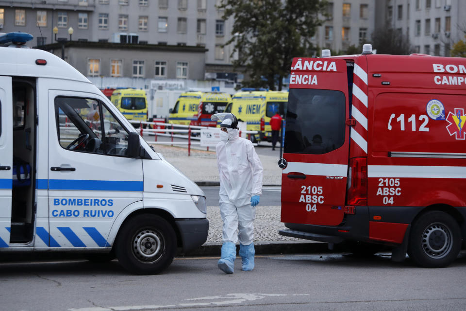 More than a dozen ambulances queue waiting to hand over their COVID-19 patients to medics at the Santa Maria hospital in Lisbon, Friday, Jan. 22, 2021. Portugal's COVID-19 surge is continuing unabated, with a new record of daily deaths, hospitalizations and patients in intensive care. (AP Photo/Armando Franca)