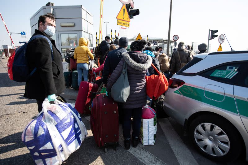 People queue to cross to Ukraine at the border crossing in Dorohusk