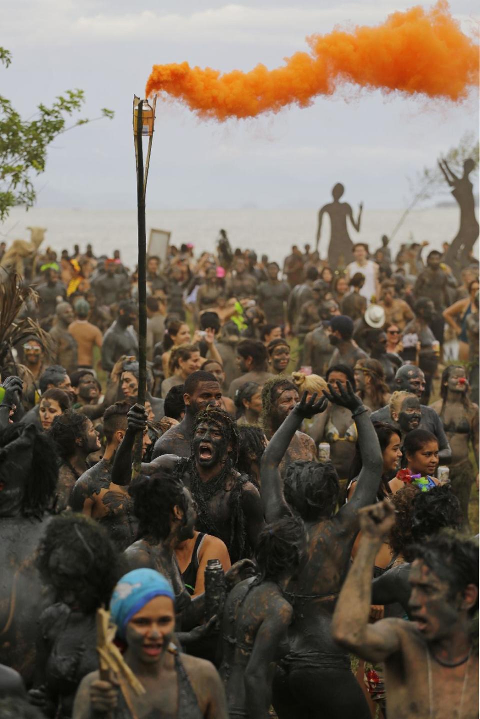 Miles de personas cubiertas de lodo bailan durante la fiesta callejera "Bloco da Lama" en Paraty, Brasil, el sábado 1 de marzo de 2014. (Foto AP/Nelson Antoine)