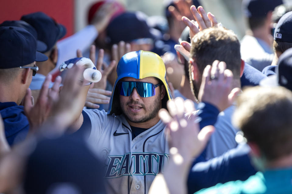 Seattle Mariners' Ty France is congratulated by teammates after hitting a three-run home run against the Los Angeles Angels during the seventh inning of a baseball game in Anaheim, Calif., Monday, Sept. 19, 2022. (AP Photo/Alex Gallardo)