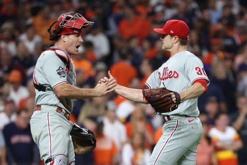 J.T. Realmuto and David Robertson celebrate the final out in the 10th.