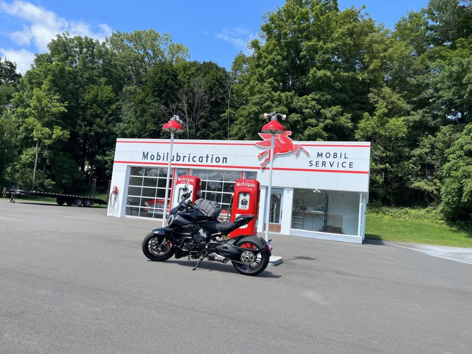 a black biker parked in front of a vintage gas station