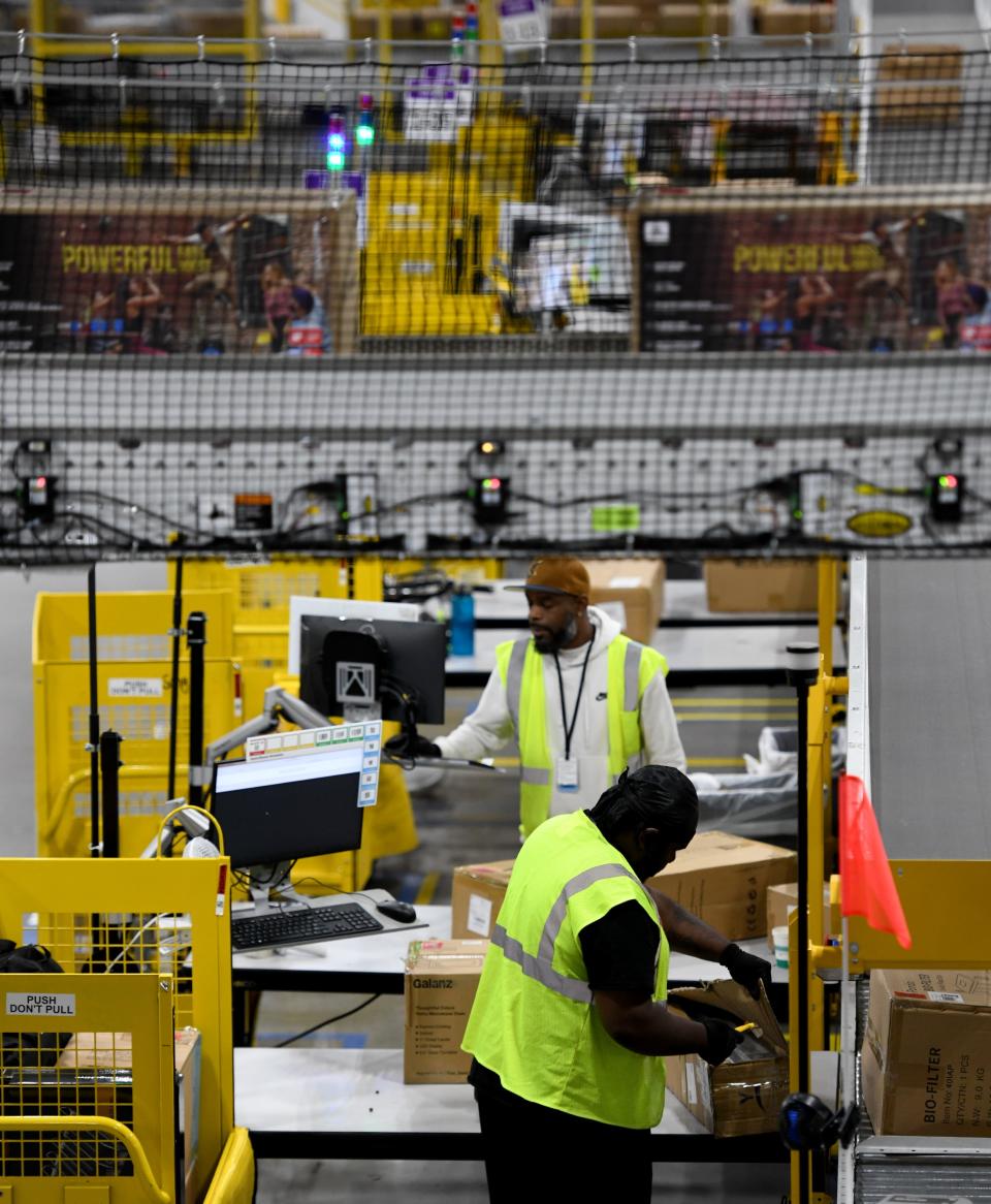 Employees package and prepare orders for shipment at Amazon.