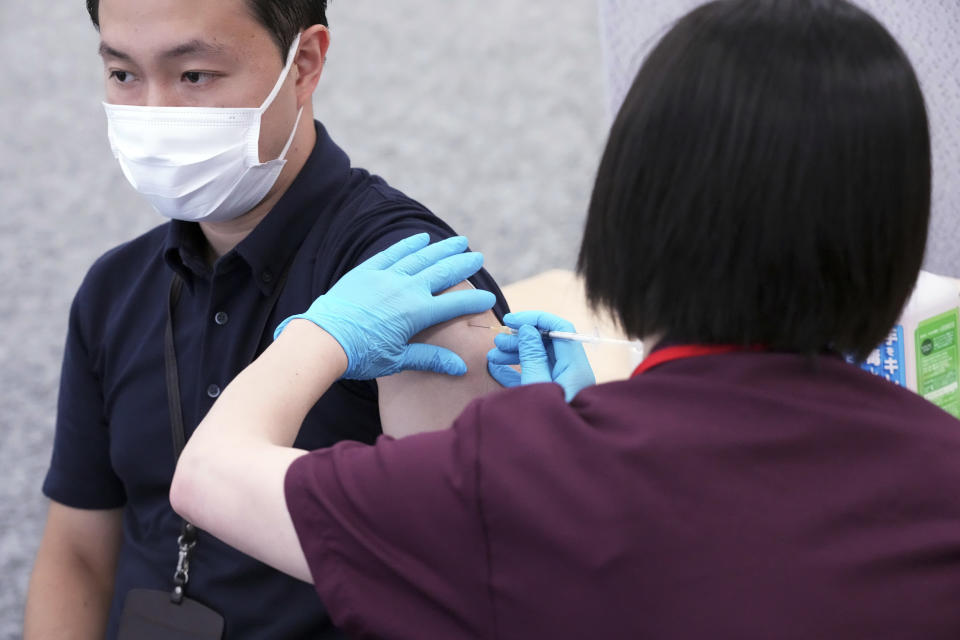 An employee of the beverage maker Suntory receives a Moderna COVID-19 vaccine shot at their office building as the company began its workplace vaccination Monday, June 21, 2021, in Tokyo. Thousands of Japanese companies began distributing COVID-19 vaccines to workers and their families Monday in an employer-led drive reaching more than 13 million people that aims to rev up the nation's slow vaccine rollout. (AP Photo/Eugene Hoshiko)