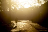 Eder Lopez, a 20-year-old MSU sophomore studying psychology, walks to his first class as the sun rises on the first day campus opens back up on Monday, Feb. 20, 2023 at Michigan State University in East Lansing, Mich., one week after three students were killed and five others injured during a mass shooting at the university. (Jake May/The Flint Journal via AP)