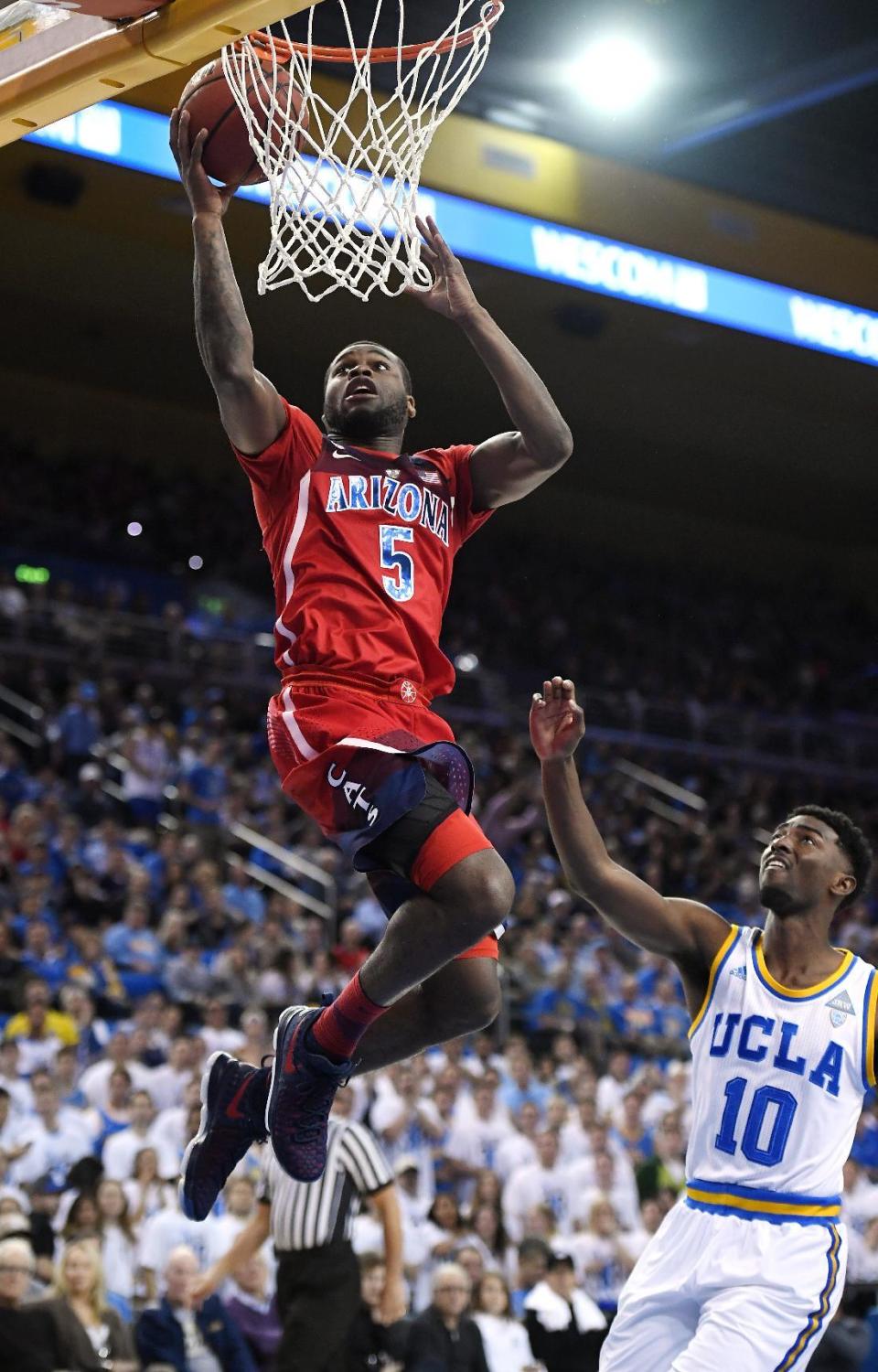 Arizona guard Kadeem Allen, left, shoots as UCLA guard Isaac Hamilton defends during the first half of an NCAA college basketball game, Saturday, Jan. 21, 2017, in Los Angeles. (AP Photo/Mark J. Terrill)