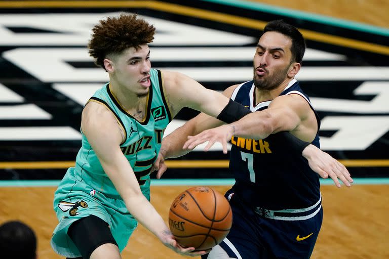 Facundo Campazzo y LaMelo Ball luchan por la pelota durante un partido entre Denver y Charlotte; el base de los Hornets fue elegido como el mejor rookie del año