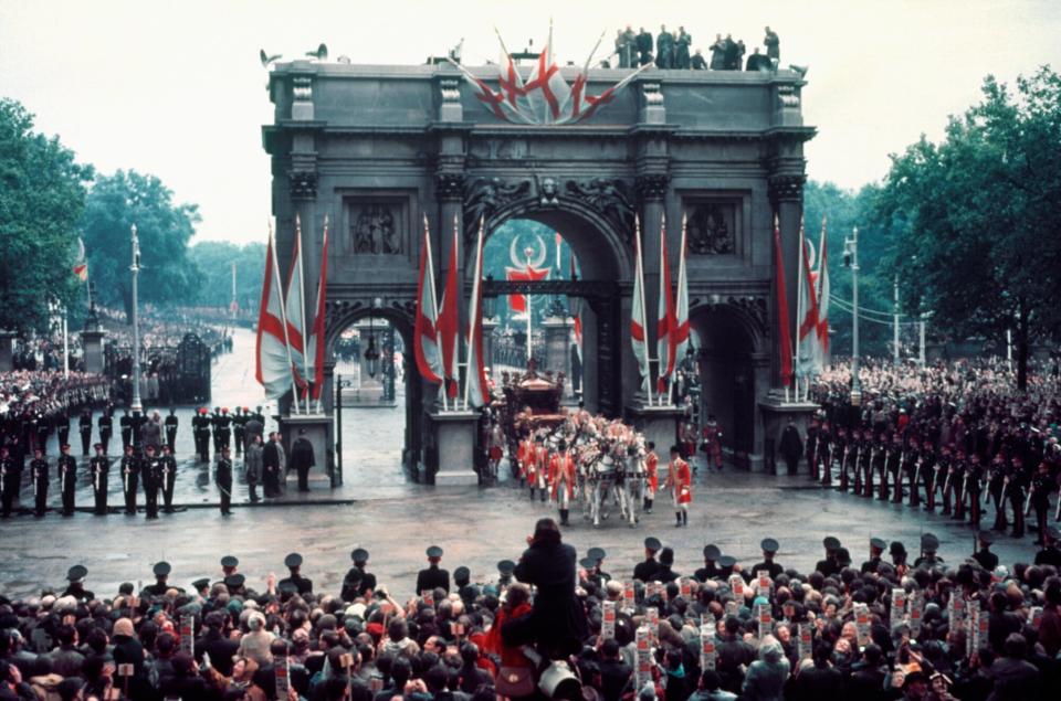 The Queen's carriage passes through Marble Arch during the 1953 Coronation procession watched by a celebrating crowd