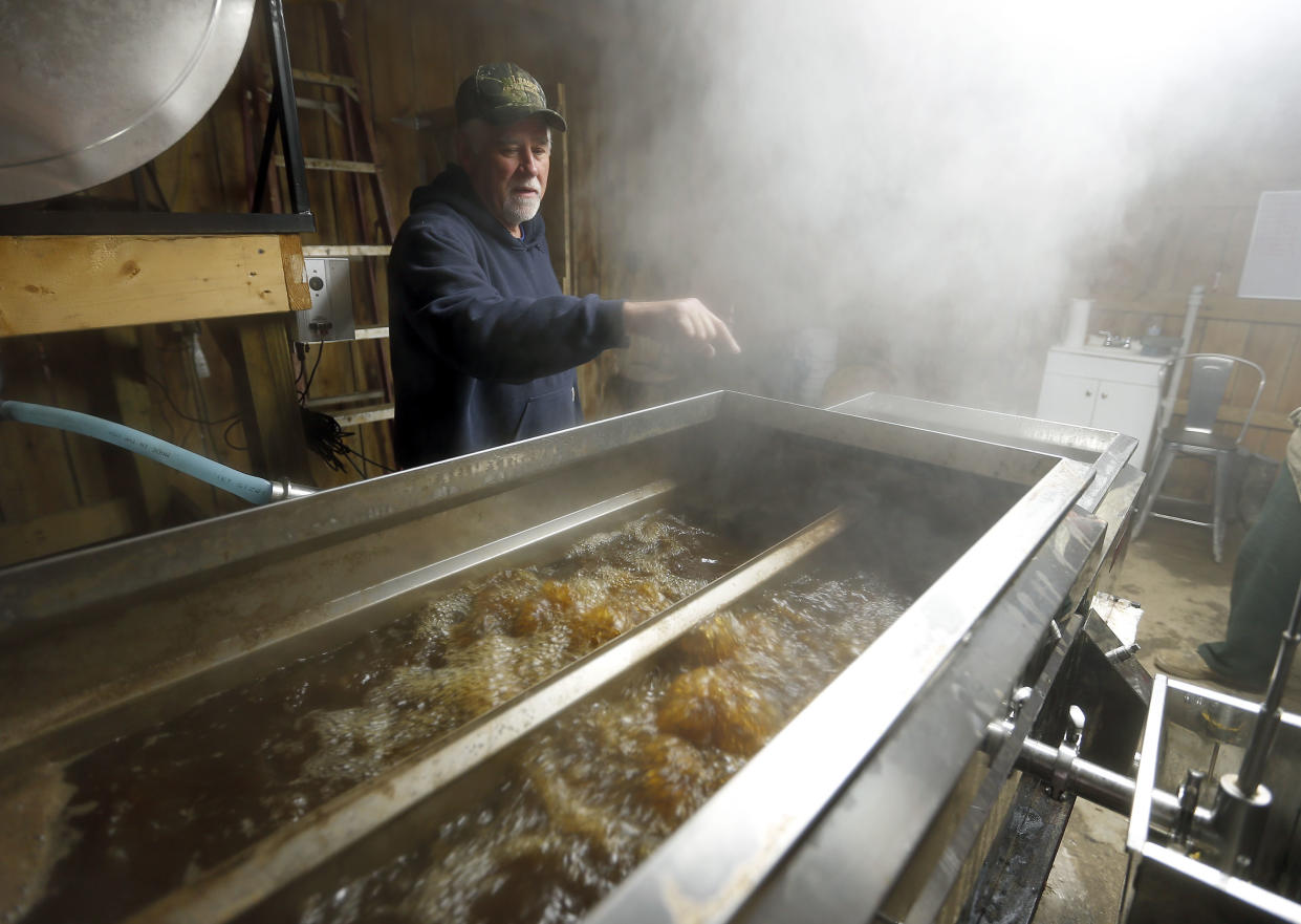 Keith Moore watches over some of the boiling sap he uses to make maple syrup on his Lawrence County Savage Farms on Feb. 14, 2018 in Louisa, Ky. (Charles Bertram/Lexington Herald-Leader via AP)