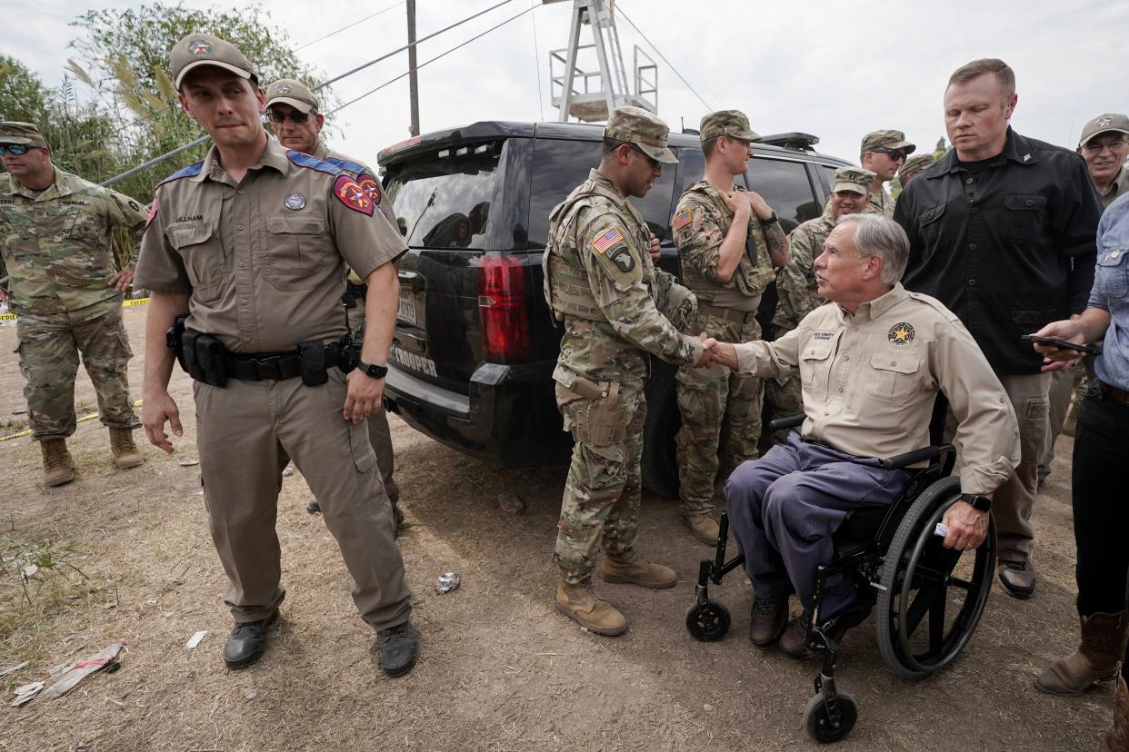 Texas Gov. Greg Abbott, right, shakes a National Guard member’s hand after speaking during a news conference along the Rio Grande  (AP)