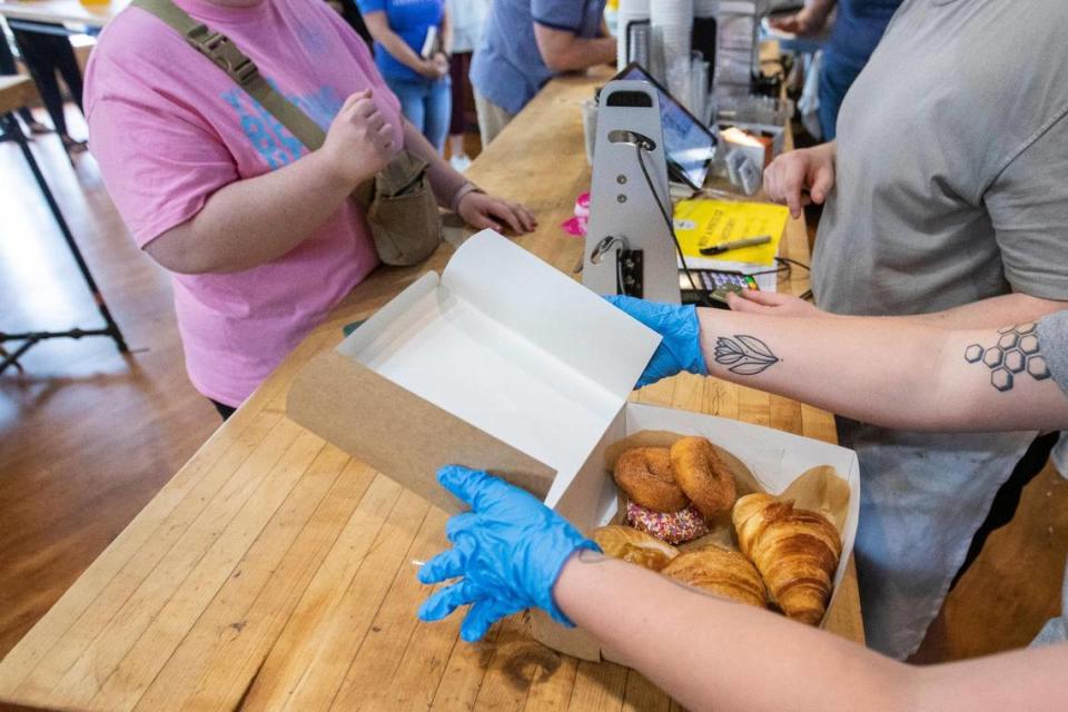 Employees box up baked goods for patrons who lined up around the corner of South Ashland and Main Street to try and purchase something on the last day of business for Magee’s Bakery in Lexington, Ky., Saturday, May 13, 2023. Some people waited in line over two hours.